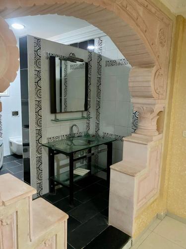 a bathroom with a sink and a mirror at Le palmier in Mezraya