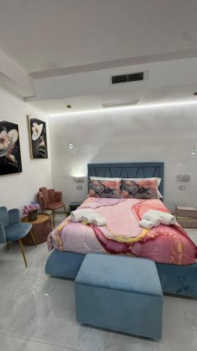 a bedroom with a large bed with a blue ottoman at Nuance Suite & Rooms in Lecce