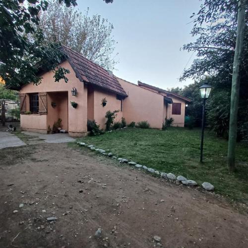 a small house with a yard and a street light at Génesis in Merlo