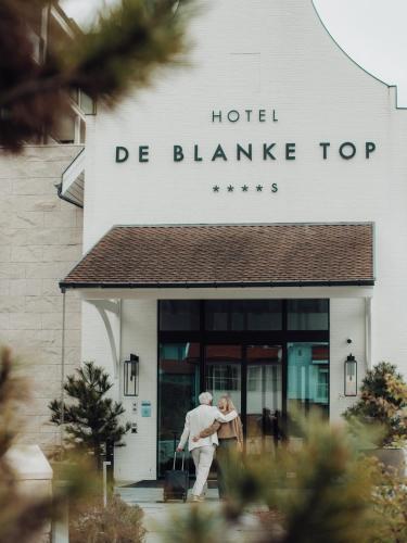 a man walking outside of a hotel dmg blume top at Hotel de Blanke Top in Cadzand-Bad