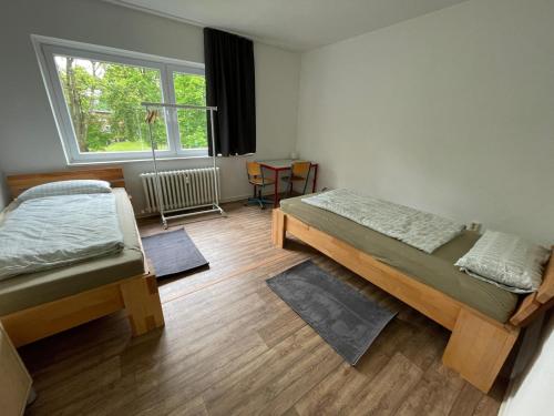 a room with two beds and a window at GM Zimmervermietung in Hamburg