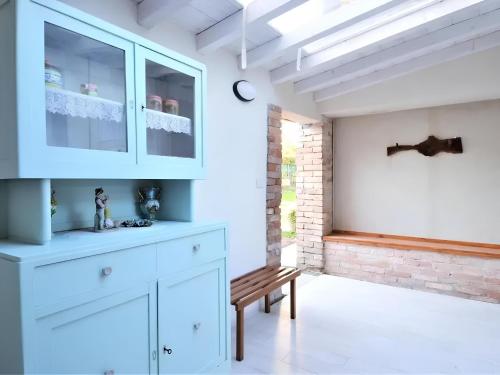 a kitchen with white cabinets and a wooden bench at La Corte di Marga Ginetta 2 - Prosecco Hills Holidays in Miane