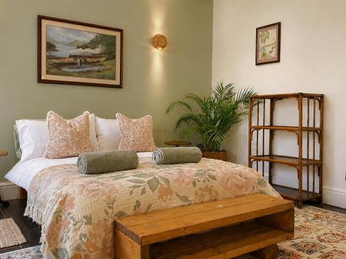 a bedroom with a bed with a bench on it at The Fig Tree in Brecon