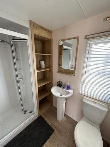 a bathroom with a toilet and a sink and a shower at Seaview Holiday Rentals - Arizona pet friendly in Chestfield