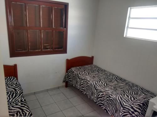 Habitación con 2 camas y ventana en Casa Dunas, en Florianópolis