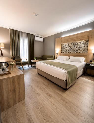 a bedroom with a large bed and a living room at Laodikya Hotel in Denizli
