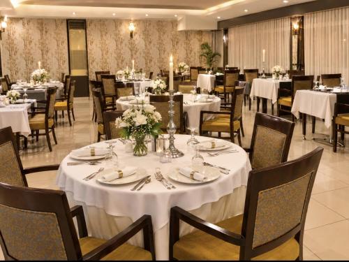 a dining room with white tables and chairs at Laodikya Hotel in Denizli