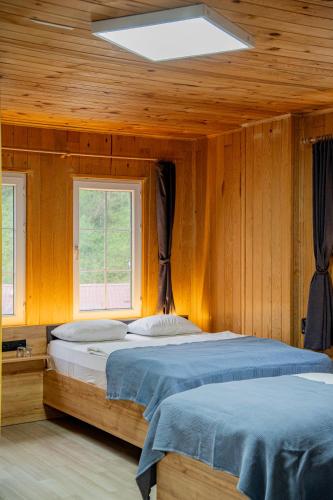 a bedroom with two beds in a room with wooden walls at 53 BRN hotel in Ardeşen