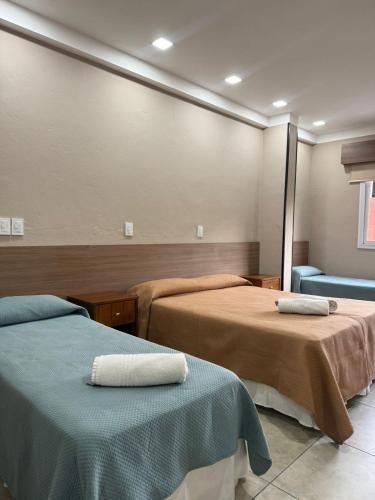 a room with two beds with towels on them at Peko's Multiparque Hotel in Villa Santa Cruz del Lago