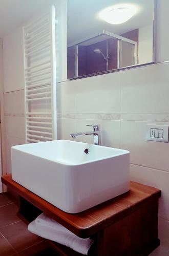 un bagno con un lavandino bianco e uno specchio di Apartment San Colombano a Valdidentro