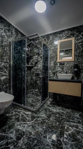 a bathroom with a glass shower and a sink at 53 BRN hotel in Ardeşen