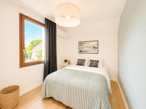 a white bedroom with a bed and a window at M114 Magnifique T2 aux portes de la douane de Moillesulaz in Gaillard