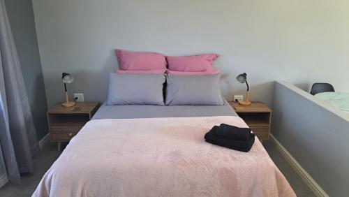 a bedroom with a bed with pink and blue pillows at Aqua Farm - Unit 3 in Teba