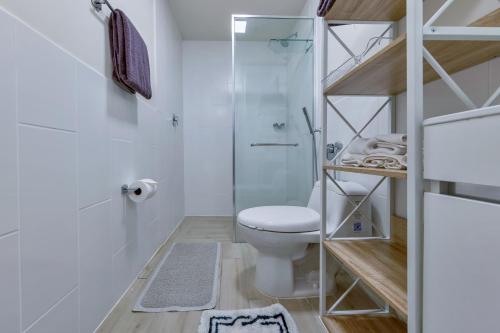 a bathroom with a toilet and a glass shower at Olas del Mar by Playa Caracol Resorts in Palmira