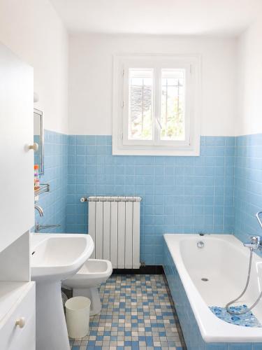 a bathroom with a tub and a toilet and a sink at La Parenthèse du Lot in Gramat