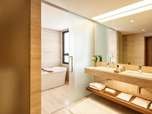a bathroom with a sink and a tub and a mirror at Hotel Fasano Belo Horizonte in Belo Horizonte