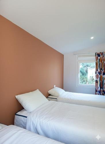 three beds in a room with a window at Camping du Pas Del Fang in Sainte-Marie-la-Mer