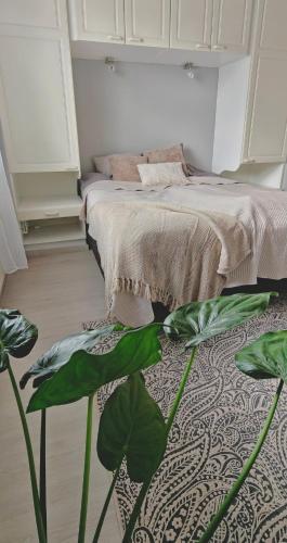 a bedroom with a bed and a green plant at Sorvarinraitin Helmi in Seinäjoki