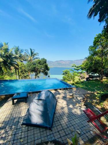 a tent and a table with a lake in the background at Diga vista resorts in Palakkad