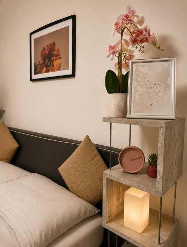 a bedroom with a bed and a shelf with flowers at Niklasdorf Bergblick/Erholung in Niklasdorf