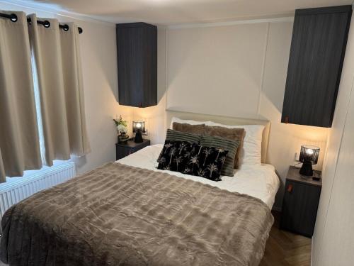 a bedroom with a large bed with pillows on it at El Bohemia Veluwe rust, natuur & zwembad voor kids in Hoenderloo