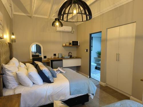 a bedroom with a bed with pillows at Bel-Air Guesthouse in Klerksdorp