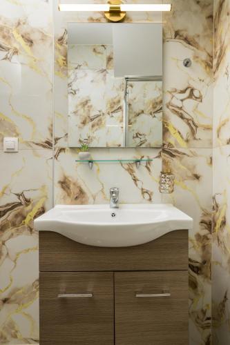 a bathroom with a sink and a mirror at Ourania Lofts and Suites in Thessaloniki