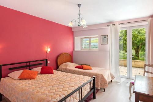 two beds in a bedroom with red walls at Gîte Charly in Salignac Eyvigues