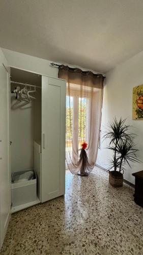 a room with a window with a curtain and a plant at A'MA CASA in Modica