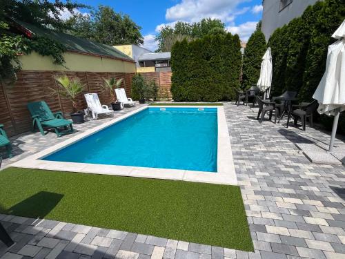 a swimming pool in a yard with chairs and a table at Hotel Brill Orosháza in Orosháza