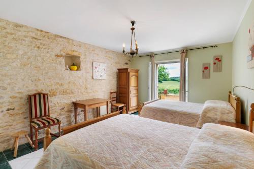 a bedroom with two beds and a table and chairs at Gite Sierra in Salignac Eyvigues