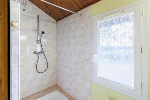 a bathroom with a shower and a window at Chalet Le Tilleul in Salignac Eyvigues