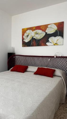 a bedroom with a bed with a painting on the wall at A'MA CASA in Modica
