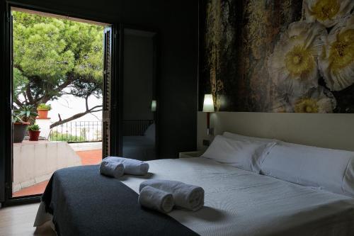 a bedroom with a bed with two towels on it at Hotel El Castell in Sant Boi del Llobregat