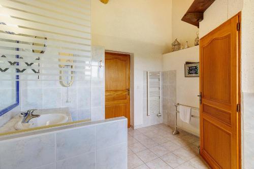 a bathroom with a tub and a sink at Gite Four De Mon Père in Salignac Eyvigues