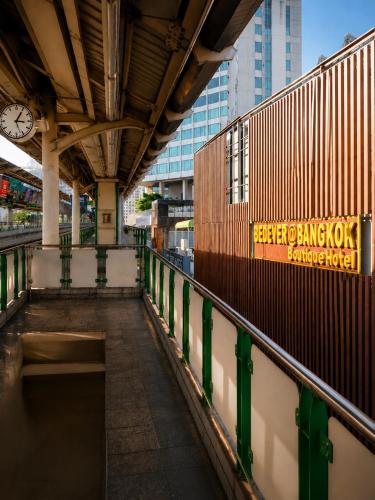 a train station with a clock on the wall at StayAt Bedever Bangkok Hotel in Bangkok