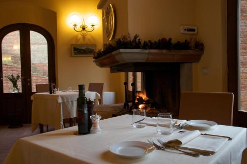 a dining room with a table and a fire place at Relais la Leopoldina in Bettolle