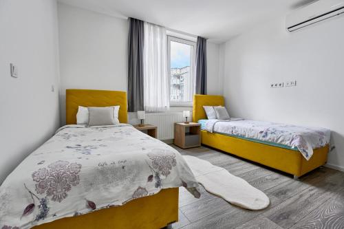 a bedroom with two beds and a window at Regency Aparthotel Sarajevo in Sarajevo