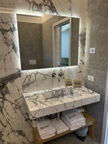 a bathroom with a marble sink and a mirror at Oliveto Apartments in Riva del Garda