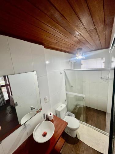 a bathroom with a white toilet and a sink at Rainha do gelo in Barra Grande