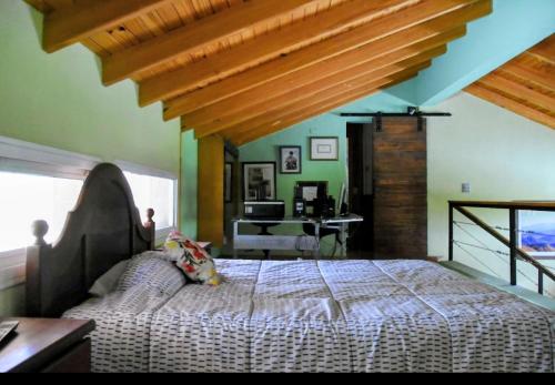 a bedroom with a large bed with a wooden ceiling at Las margaritas in Uspallata