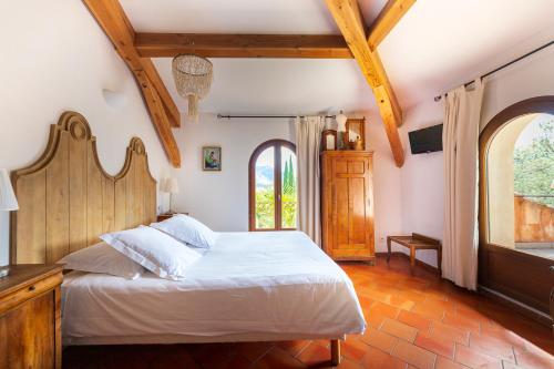 a bedroom with a bed and a large window at La Ferme Rose-Hôtel de Charme in Moustiers-Sainte-Marie