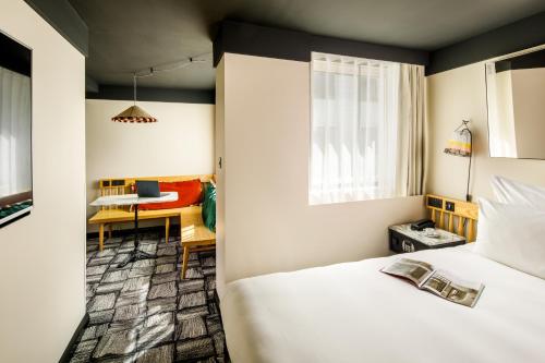 a bedroom with a bed and a table with a laptop at ARK Shoreditch in London