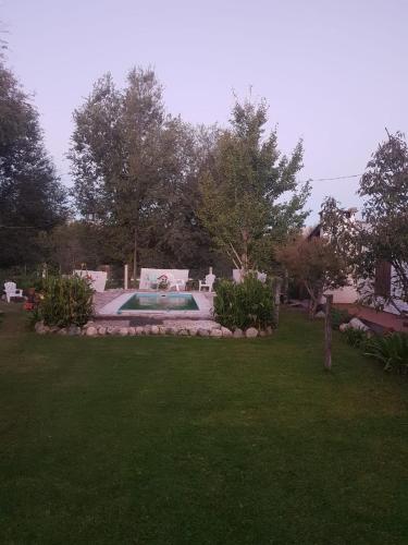 a backyard with a swimming pool and a lawn at tabaquillo in Villa Cura Brochero