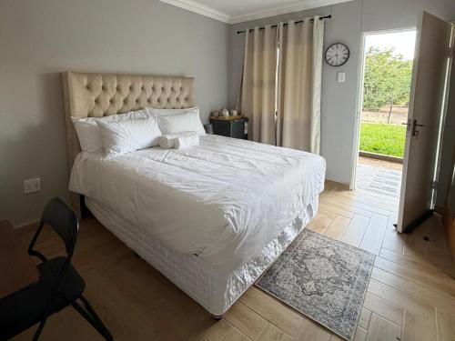 a bedroom with a large bed and a clock on the wall at Watupa Chalets in Rundu