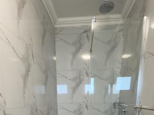 a bathroom with a marble shower with a glass door at Watupa Chalets in Rundu