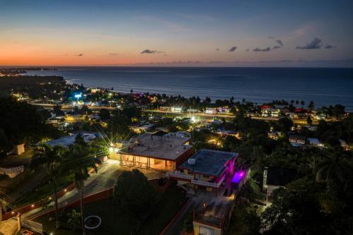 an aerial view of a city at night with the ocean at Villa del Enseuno- Pristine View and Infinity Pool in Luquillo