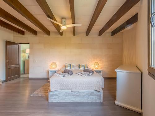 a bedroom with a bed and a ceiling fan at Villa Serena by 3VILLAS in S'Algar