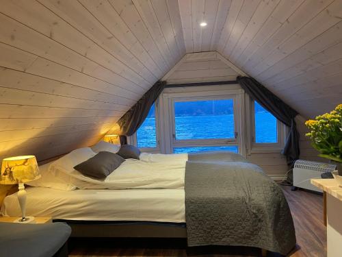 a large bed in a room with a window at Småstranda 7B Boathouse in Store Teisten