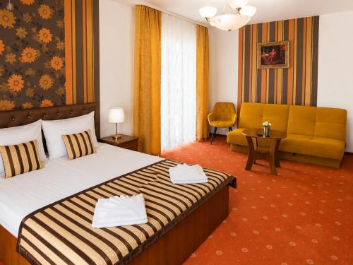 a hotel room with a bed and a couch at Pałacyk in Międzywodzie